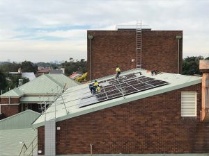 Men installing solar panels on rooftop