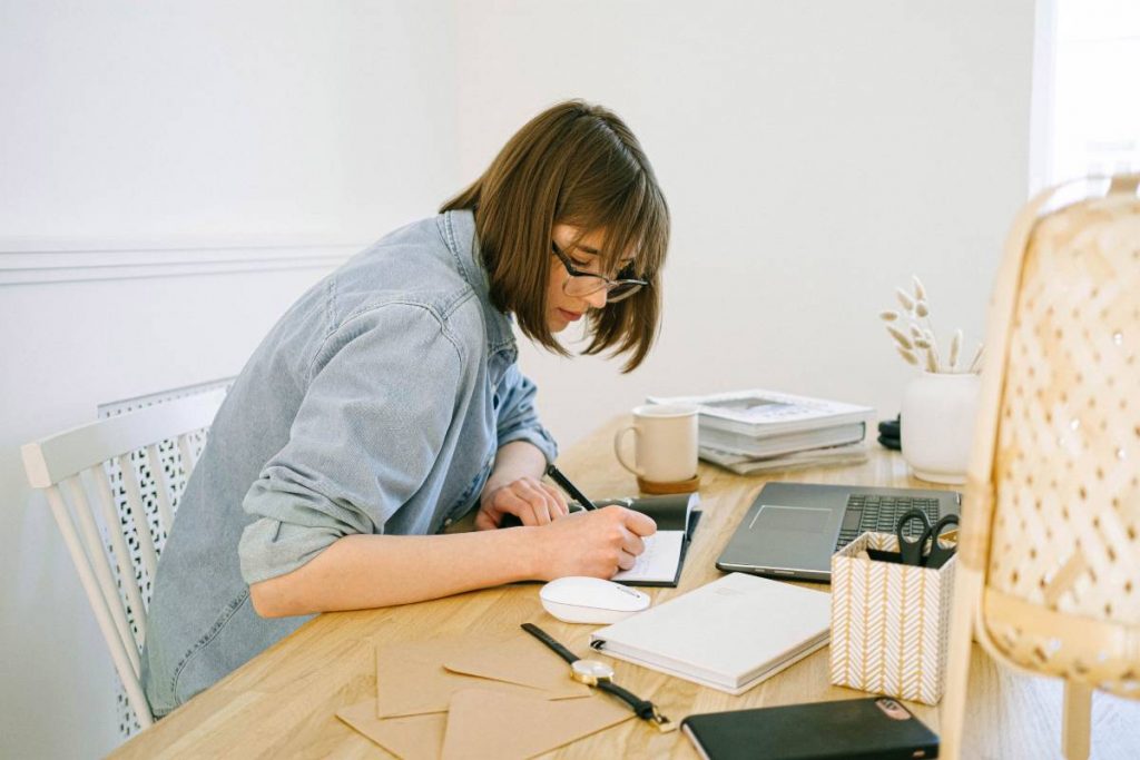 woman writing at desk